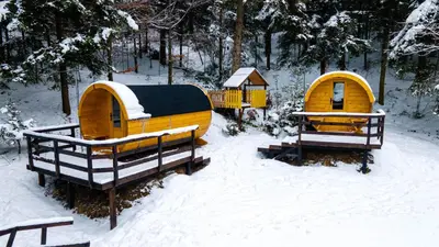 a group of three small homes in the snow at Beczki Pod Lasem in Trzemeśnia