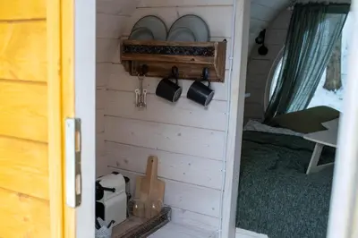a door of a tiny house with a wall with plates at Beczki Pod Lasem in Trzemeśnia