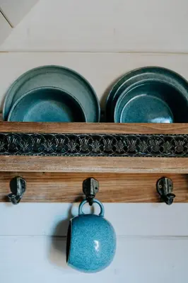 two blue plates and a tag on a shelf at Beczki Pod Lasem in Trzemeśnia