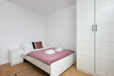 a white bedroom with a bed and white cabinets at Family Apartment Nearto Old Town Vermelo by NEARTOpl in Kraków