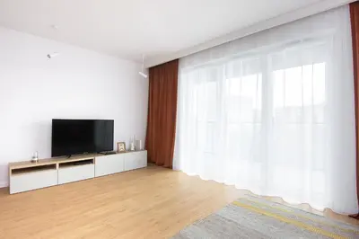 a living room with a tv and a large window at Family Apartment Nearto Old Town Vermelo by NEARTOpl in Kraków