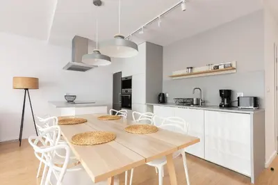 a kitchen and dining room with a wooden table and chairs at Family Apartment Nearto Old Town Vermelo by NEARTOpl in Kraków