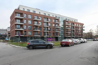 a row of cars parked in front of a building at Lotniczówka Apartments by Renters Prestige in Kraków