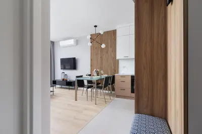 a kitchen and living room with a table and chairs at Lotniczówka Apartments by Renters Prestige in Kraków
