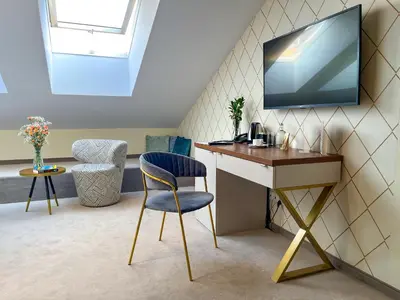 a room with a desk and a tv on a wall at Xerion Hotel in Kraków