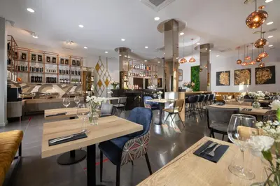 a restaurant with tables and chairs and a bar at Xerion Hotel in Kraków