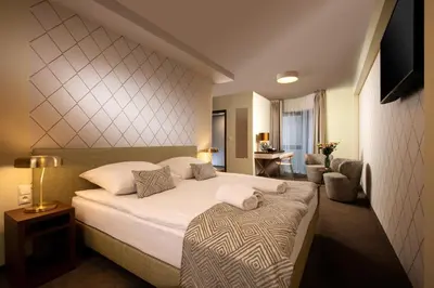 a hotel room with a bed and a chair at Xerion Hotel in Kraków