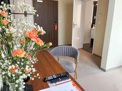 a table with a vase of orange flowers on it at Xerion Hotel in Kraków
