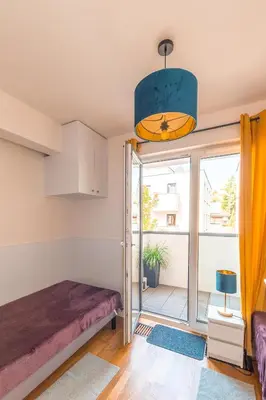 a room with a bed and a balcony at Apartament Chmielna Gold in Kraków