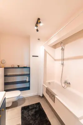 a bathroom with a tub and a toilet and a sink at Apartament Chmielna Gold in Kraków