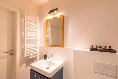 a bathroom with a sink and a mirror at Apartament Chmielna Gold in Kraków