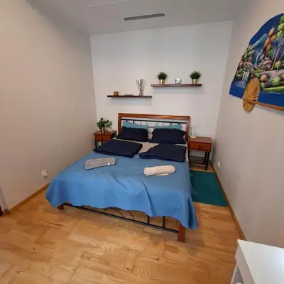 a bedroom with a bed with blue sheets and blue pillows at Apartament Wielopole 17 in Kraków