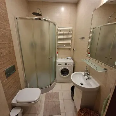 a bathroom with a toilet sink and a washing machine at Apartament Wielopole 17 in Kraków