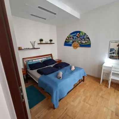 a bedroom with a bed with blue sheets and a desk at Apartament Wielopole 17 in Kraków