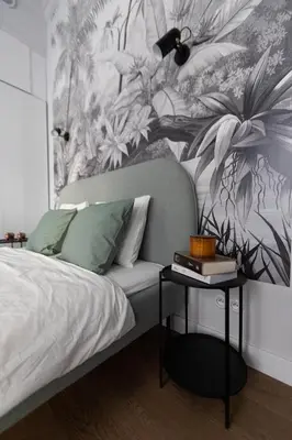 a bedroom with a bed with a plant mural on the wall at LION apartments - Premium STUDIO with BALCONY in Kraków
