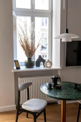 a table and a chair in a room with a window at LION apartments - Premium STUDIO with BALCONY in Kraków