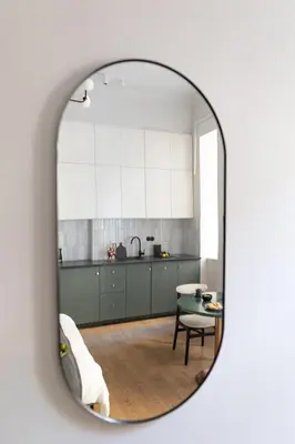 a kitchen with white cabinets and a table in a mirror at LION apartments - Premium STUDIO with BALCONY in Kraków