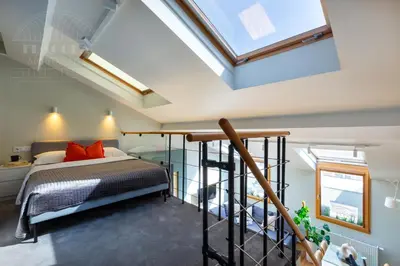a bedroom with a bed and a skylight at ArtSquare Kazimierz Fragola Apartments in Kraków
