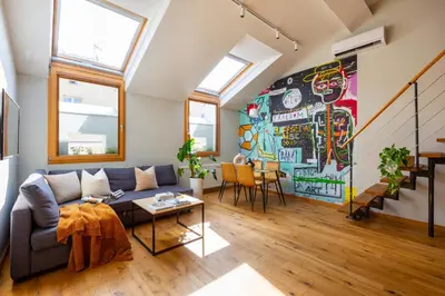 a living room with a couch and a mural at ArtSquare Kazimierz Fragola Apartments in Kraków