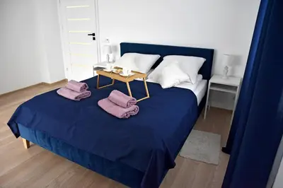 a bedroom with a blue bed with towels on it at Dwa Widoki Apartamenty in Zubrzyca Górna