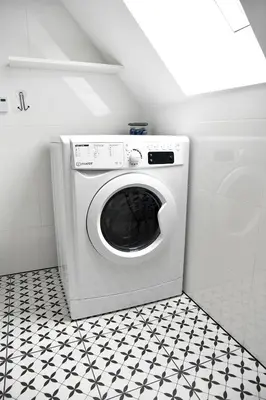 a washing machine in a bathroom with a black and white floor at Dwa Widoki Apartamenty in Zubrzyca Górna