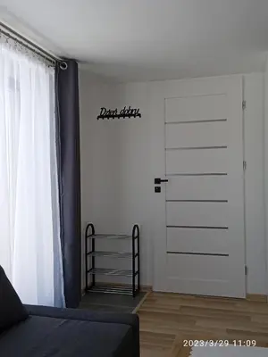 a bedroom with a door with a sign on the wall at Dwa Widoki Apartamenty in Zubrzyca Górna