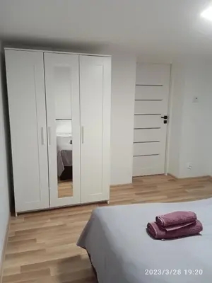 a white bedroom with a bed and a closet at Dwa Widoki Apartamenty in Zubrzyca Górna