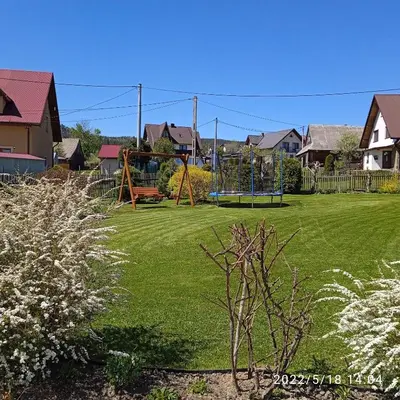 a playground in a yard with a green lawn at Dwa Widoki Apartamenty in Zubrzyca Górna