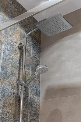 a shower with a shower head in a bathroom at St. Florian cozy loft in Kraków