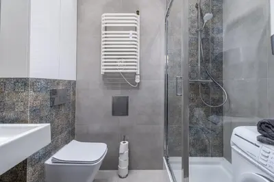 a bathroom with a shower with a toilet and a sink at St. Florian cozy loft in Kraków