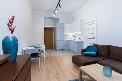 a living room with a couch and a kitchen at St. Florian cozy loft in Kraków