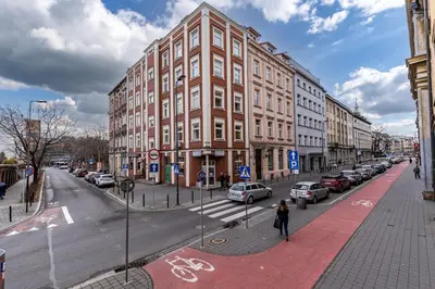 a woman walking down a street next to a building at St. Florian cozy loft in Kraków