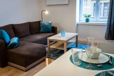 a living room with a couch and a table at St. Florian cozy loft in Kraków