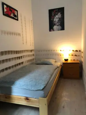 a bedroom with a bed and a lamp on a night stand at Nr 3 in Kraków