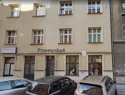 a building with cars parked in front of it at Apartament on Kazimierz in Kraków
