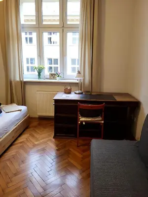 a bedroom with a desk and a bed and a window at Apartament on Kazimierz in Kraków