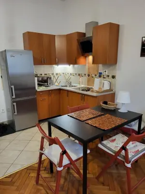 a kitchen with a table and chairs and a refrigerator at Apartament on Kazimierz in Kraków