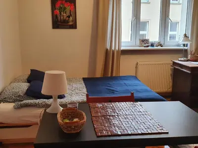 a bedroom with a bed and a table with a lamp at Apartament on Kazimierz in Kraków
