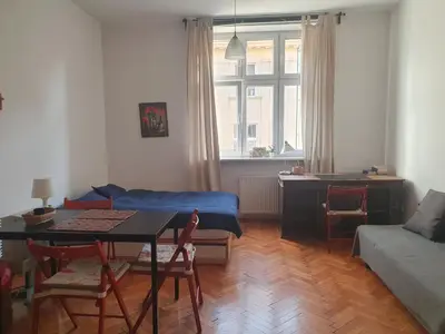 a living room with a table and a couch at Apartament on Kazimierz in Kraków