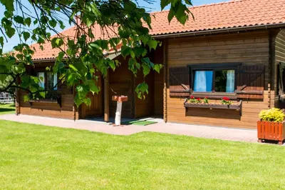 a wooden house with two windows with flowers on it at Noclegi-Dobczyce in Dobczyce