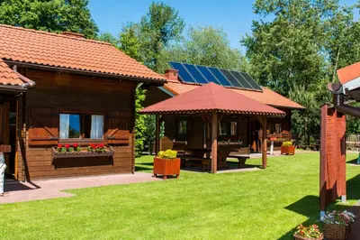 a log cabin with a solar roof and a bench at Noclegi-Dobczyce in Dobczyce