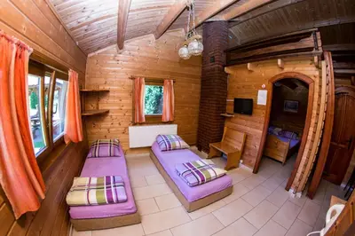 a room with purple beds in a wooden cabin at Noclegi-Dobczyce in Dobczyce