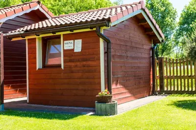 a small red shed with a window and a potted plant at Noclegi-Dobczyce in Dobczyce