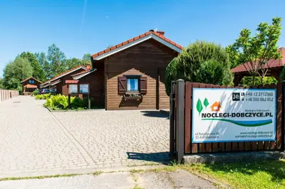 a sign in front of a house with a building at Noclegi-Dobczyce in Dobczyce