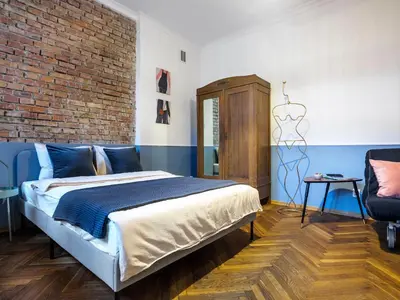 a bedroom with a bed and a brick wall at Silent blue apartment / Kochanowskigo St in Kraków
