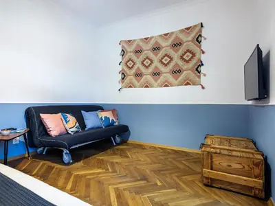 a living room with a black couch and a television at Silent blue apartment / Kochanowskigo St in Kraków