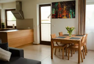 a kitchen and dining room with a table and chairs at Apartament Słoneczna Rapsodia - blisko Parku Zdrojowego - piękny widok - ogród - taras in Rabka