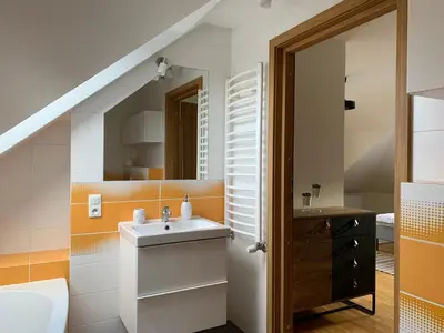 a bathroom with a sink and an orange at Apartament Słoneczna Rapsodia - blisko Parku Zdrojowego - piękny widok - ogród - taras in Rabka