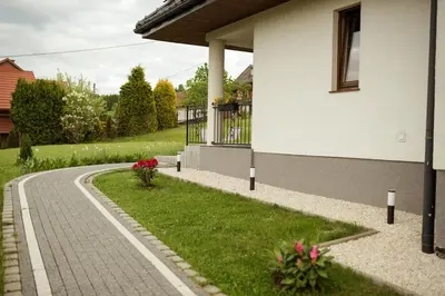 a house with a walkway next to a house at Apartament Słoneczna Rapsodia - blisko Parku Zdrojowego - piękny widok - ogród - taras in Rabka