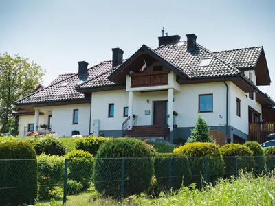 a large white house with a tiled roof at Apartament Słoneczna Rapsodia - blisko Parku Zdrojowego - piękny widok - ogród - taras in Rabka